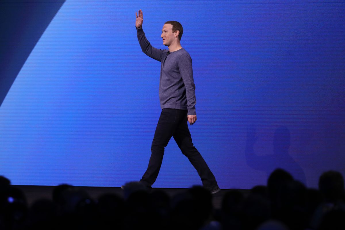 Facebook CEO Mark Zuckerberg walking onstage and waving.