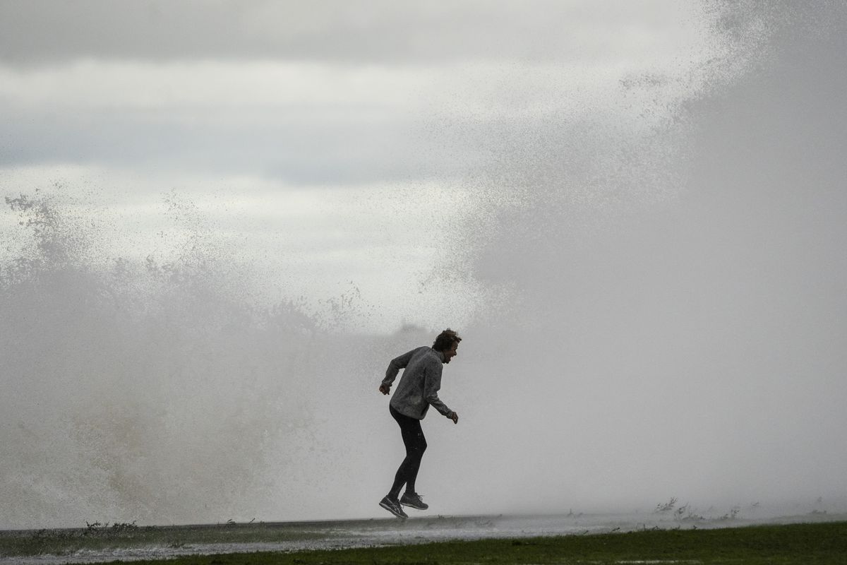 A jogger gets hit with a high wave on the Lakefront Trail near West Fullerton Avenue on the North Side, Monday afternoon, Oct. 25, 2021.