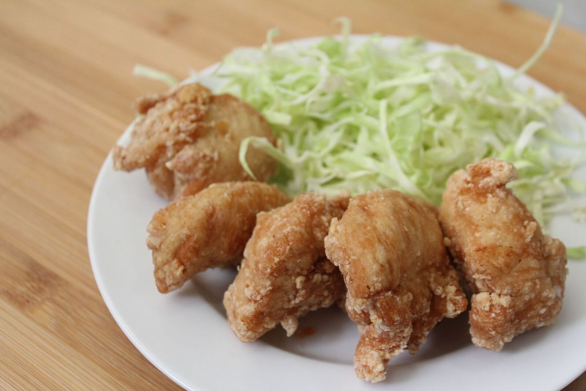A plate of Japanese style fried chicken nuggets with shredded cabbage.
