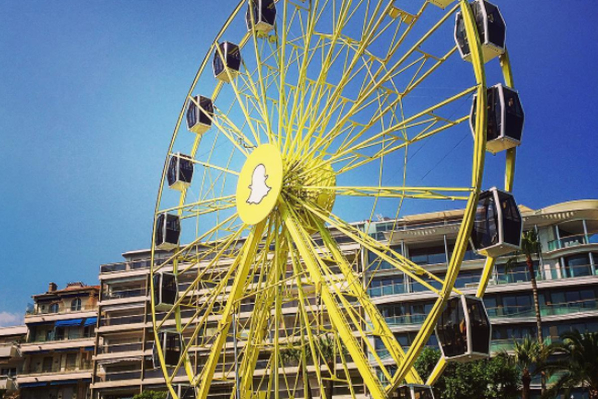a Snapchat-themed ferris wheel in front of a hotel