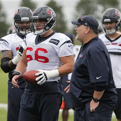 Houston Texans center Nick Martin (66) along with other lineman takes instructions from offensive line coach Mike Devlin, right front, during a morning practice at the Dallas Cowboys training facility, Monday, Aug. 28, 2017, in Frisco, Texas. The Texans are working out in the practice facility of the Dallas Cowboys because of floods pounding Houston. An exhibition game in the Texans' stadium Thursday might be moved to the home of the Cowboys.  