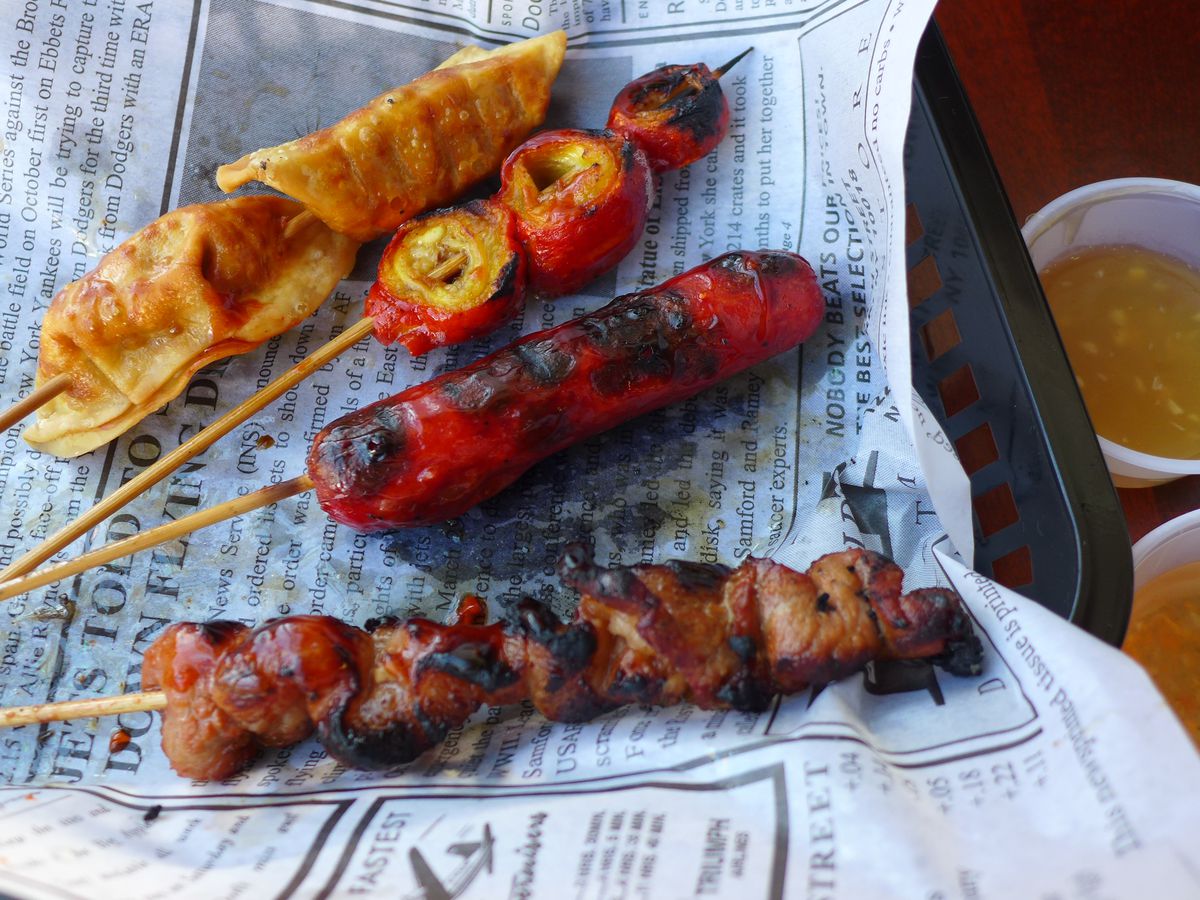 Four skewers with pig intestine, hot dog, wontons, and chicken hearts.