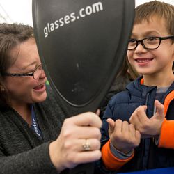 Angie Drope, left, helps Carlos Avila, right, pick out a pair of glasses during SightFest at the Jordan School District Auxiliary Services building in West Jordan on Thursday, Dec. 8, 2016. SightFest is a partnership between Friends for Sight and the Utah Optometric Association that on Thursday provided free eye exams and glasses for 125 students from Title I schools in the Jordan School District.