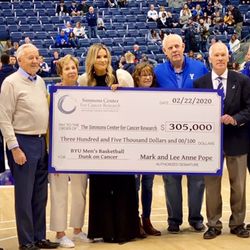 Lee Anne Pope and donors present a check to BYU’s Simmons Center for Cancer Research before the BYU-Gonzaga game on Feb. 22.