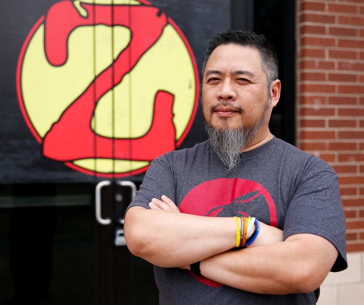 ZaLat Pizza founder Khanh Nguyen posing in front of the chain’s logo.