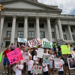 FILE - People hold signs calling for the freeing of Josh Holt at the Utah State Capitol in Salt Lake City on Saturday, July 30, 2016. Family members and supporters held a rally to call for the release of Josh Holt, who has been jailed in Venezuela.