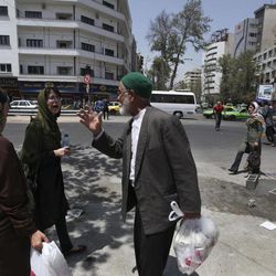 An Iranian elderly man, a supporter of the presidential candidate Hasan Rowhani, talks with two women on a street of Tehran, Iran, a day after the election, Saturday, June 15, 2013. Iran's reformist-backed presidential candidate surged to a wide lead in early vote counting Saturday, a top official said, suggesting a flurry of late support could have swayed a race that once appeared solidly in the hands of Tehran's ruling clerics. The strong margin for former nuclear negotiator Rowhani may be enough to give him an outright victory and avoid a two-person runoff next Friday. 