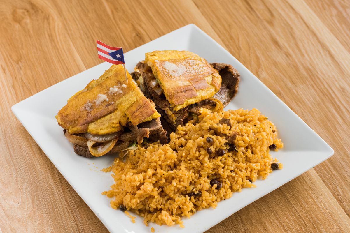 A jibarito sandwich with a side of rice.