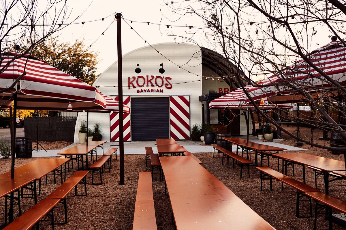 An outdoor building that has a sign reading Koko’s Bavarian with picnic tables out front.