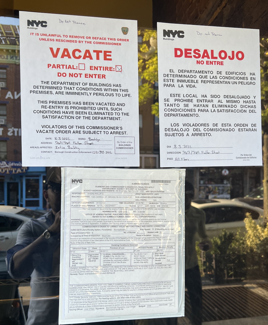 Three vacate noticed posted to the exterior window of Fort Greene’s Greene Grape Provisions.