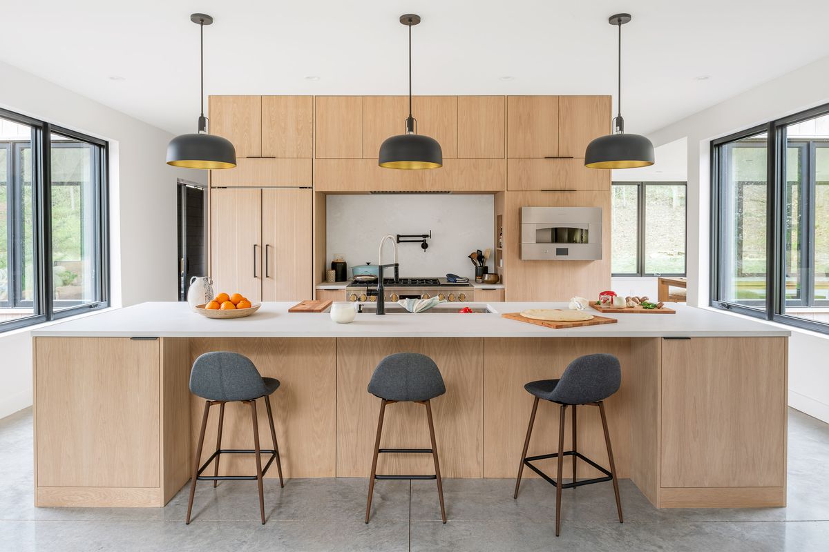 Breakfast bar in the Modern Barnhouse. Pendant lights align over the three chairs at the island. 