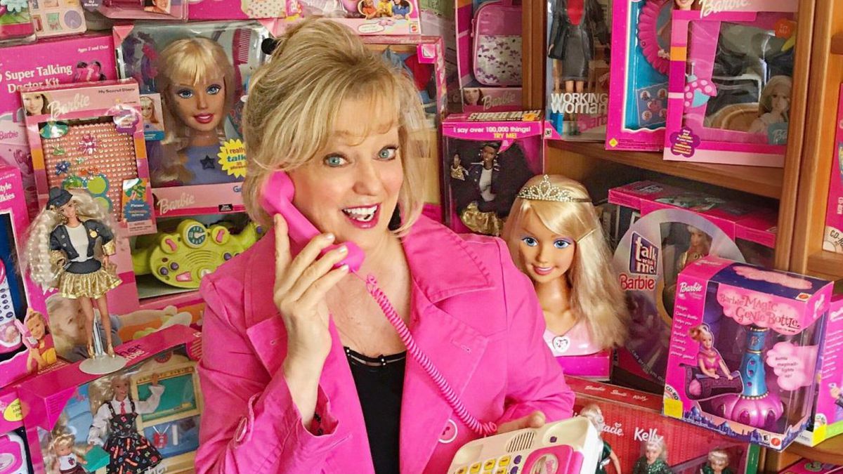 Chris Anthony Lansdowne holding a pink phone up to her ear, surrounded by all the toys she voiced.