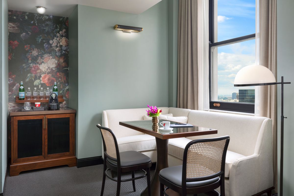 A hotel room with blue and floral walls and views across Atlanta.