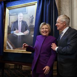Former Secretary of State Hillary Clinton, left, smiles as Senate Minority Leader Sen. Harry Reid, D-Nev., poses her for a photograph during a ceremony to unveil a portrait of Reid, on Capitol Hill, Thursday, Dec. 8, 2016, in Washington. 