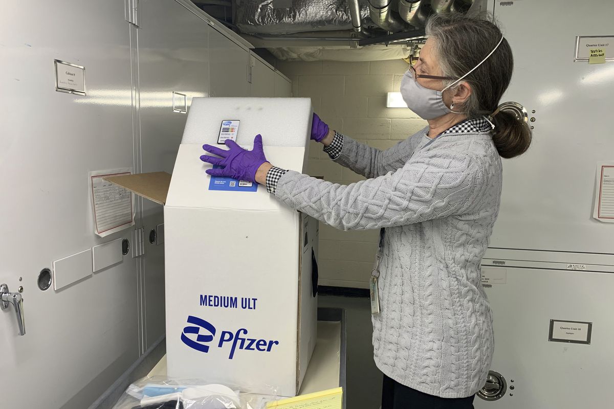 Curator Diane Wendt shows that specialized container used to ship super-cold doses of the Pfizer COVID-19 vaccine. The package and other items related to the first dose of vaccine administered in the United States have been donated to the Smithsonian’s Museum of American History.