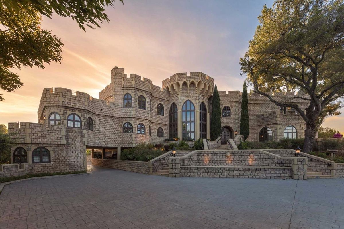 A Silicon Valley home that looks like a castle, complete with Gothic windows and a central tower with crenellations.