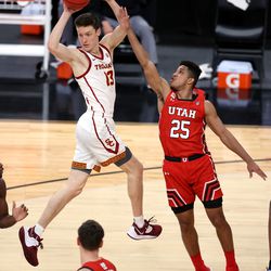 USC Trojans guard Drew Peterson (13) turns in the air to pass the ball away from Utah Utes guard Alfonso Plummer (25) as Utah and USC play in the Pac-12 Tournament at T-Mobile Arena in Las Vegas on Thursday, March 11, 2021.