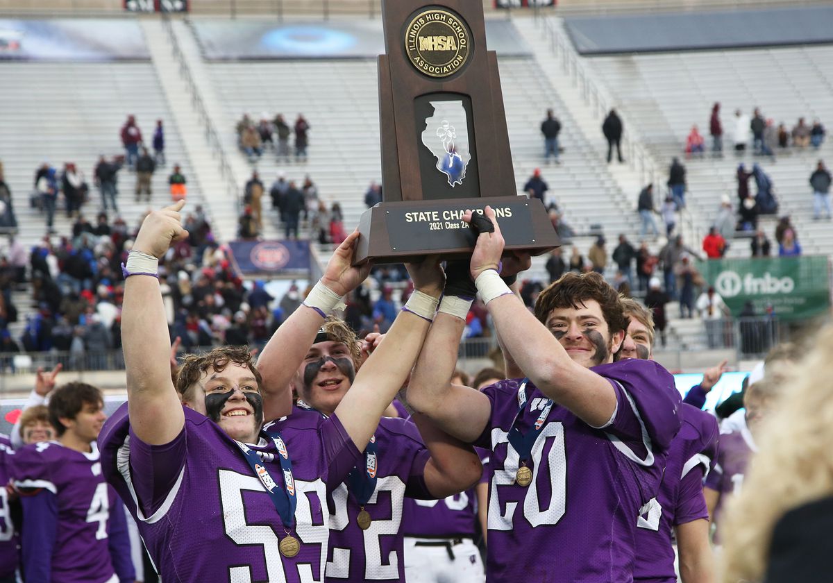 Wilmington captains Dominic Dingillo (59) and Allan Richards (20) hoist the IHSA 2A State Championship trophy.
