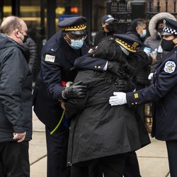 Erica Lopez, daughter of Guadalupe “Lupe” Lopez, hugs her dad’s coworkers and supporters as his funeral procession stops in front of the Office of Emergency Management and Communications, Monday morning, Nov. 30, 2020. Lupe Lopez, 58, a 911 dispatcher in Chicago for over 33 years, died Nov. 16 of complications from COVID-19.