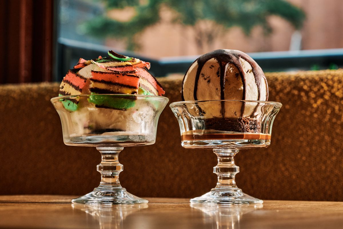 A tricolore cookie sundae and a mint brownie sundae sit side by side in ornamental glasses