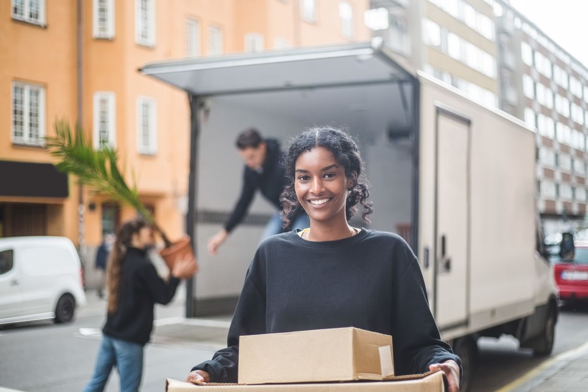 A young woman unloads a moving truck
