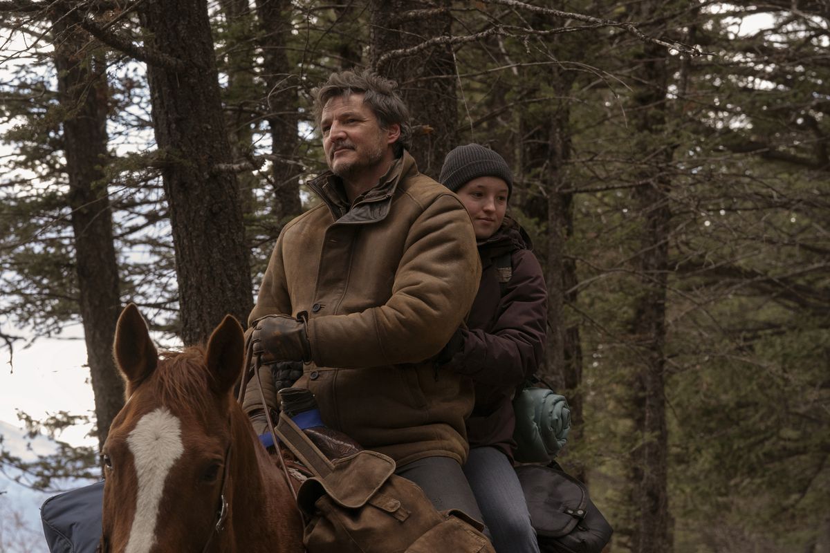 Joel (Pedro Pascal) smiling on a horse with Ellie (Bella Ramsey) riding behind him looking down