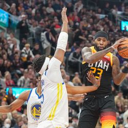 Utah Jazz forward Royce O’Neale, right, saves the ball against Golden State Warriors players during an NBA game at Vivint Arena in Salt Lake City on Saturday, Jan. 1, 2022.
