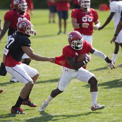 University of Utah running back Zack Moss attempts to stop teammate Caleb Repp during a drill during football practice in Salt Lake City on Thursday, Aug. 3, 2017.