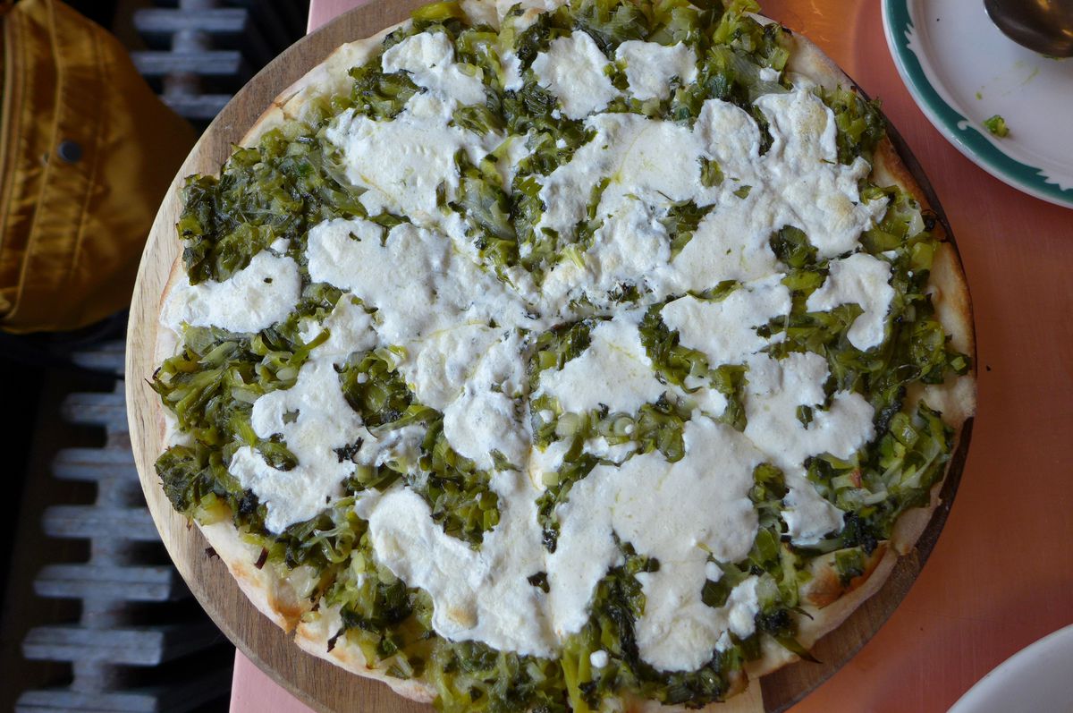 A round pie with lots of leeks and mozzarella.