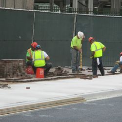 4:20 p.m. Workers laying down pavement bricks, along the Sheffield sidewalk - 