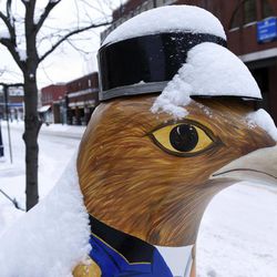 A worker clears the sidewalk near a chicken sculpture in Annapolis, Md., Tuesday, Feb. 17, 2015, after several inches of snow closed the federal government and schools. The chicken sculptures sprinkled in the arts district of Annapolis pay homage to the debate at the time in City Hall over laws allowing the raising of backyard poultry. The law eventually passed, bringing chickens both real and abstract to Annapolis. 