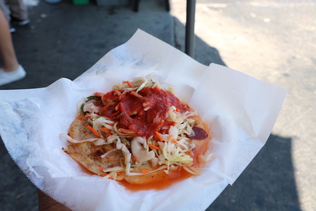 Pupusa topped with curtido with sauce at LA’s Two Guys Plaza Salvadoran street market.