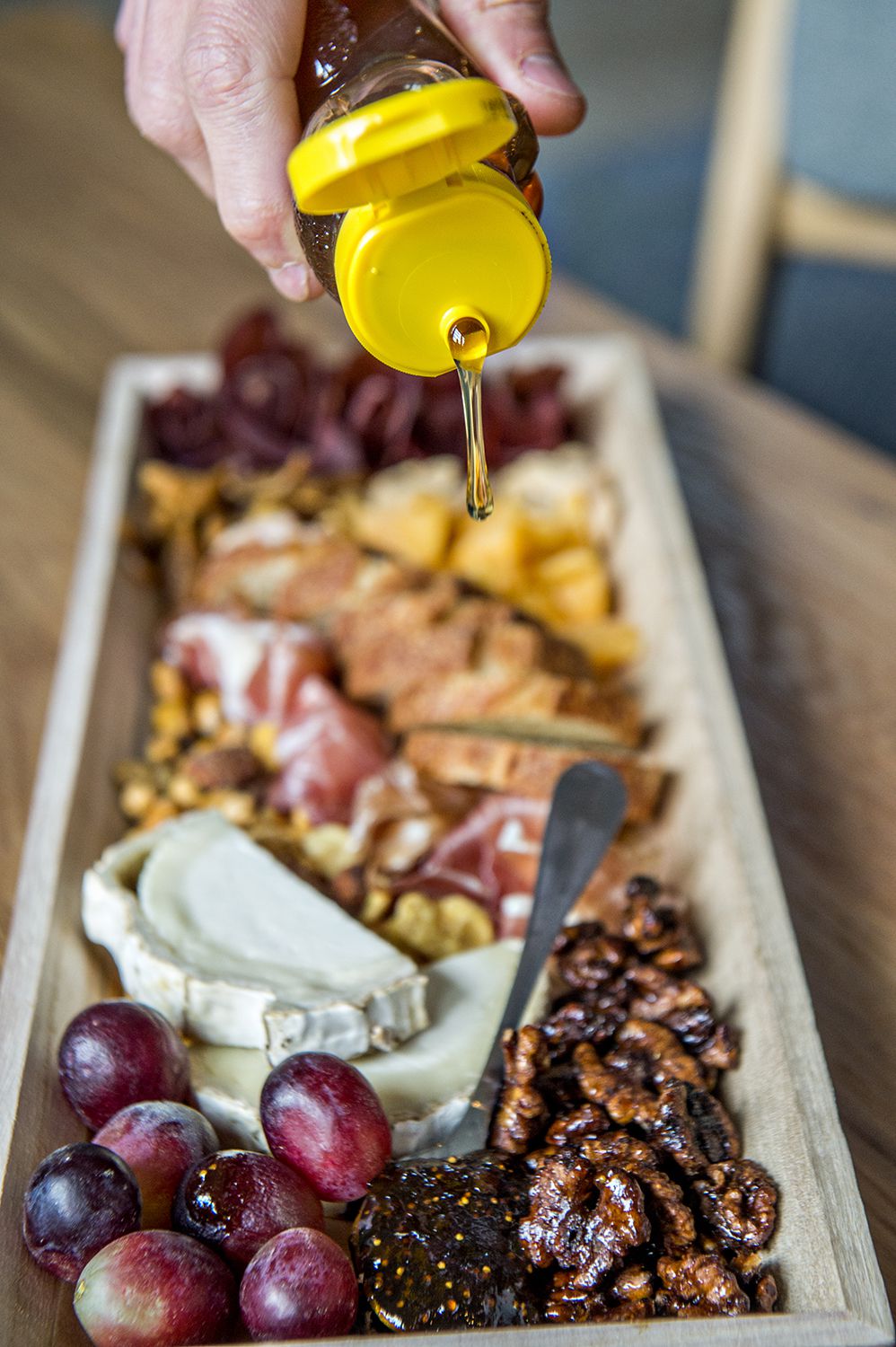Fresh poured honey to go atop the cheese on Mondo Mini’s charcuterie board.