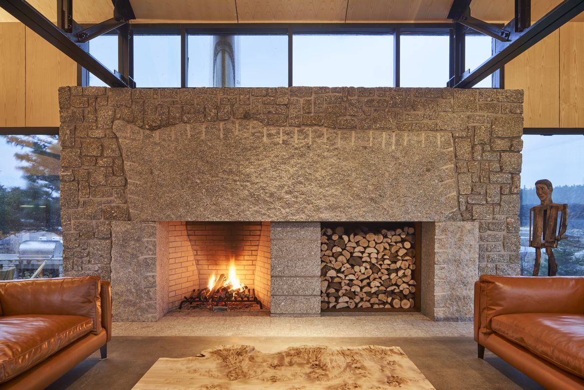 A large rectangular stone fireplace with one recessed area for a fire and another for firewood storage. 