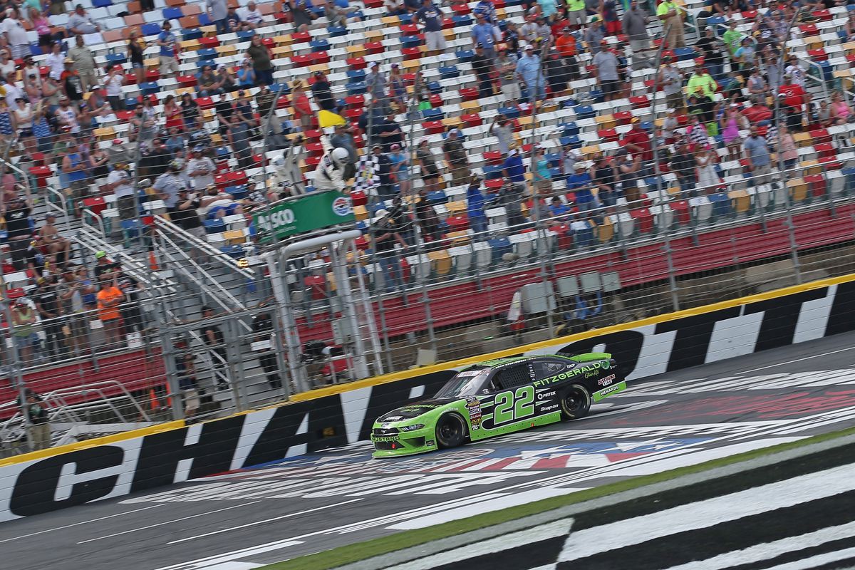 Brad Keselowski, driver of the #22 Fitzgerald Glider Kits Ford, takes the checkered flag to win the NASCAR Xfinity Series ALSCO 300 at Charlotte Motor Speedway on May 26, 2018 in Charlotte, North Carolina.