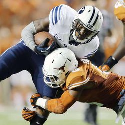 BYU's Jamaal Williams is hit by Quandre Diggs as BYU and Texas play Saturday, Sept. 6, 2014, in Austin Texas. BYU won 41-7.