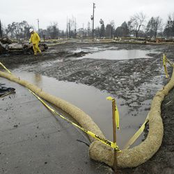 A rolls of wattle for erosion control circle a homesite in the wildfire damaged Coffey Park neighborhood, Monday, Jan. 8, 2018, in Santa Rosa, Calif. Storms brought rain to California on Monday and increased the risk of mudslides in fire-ravaged communities in devastated northern wine country and authorities to order evacuations farther south for towns below hillsides burned by the state's largest-ever wildfire. (AP Photo/Eric Risberg)