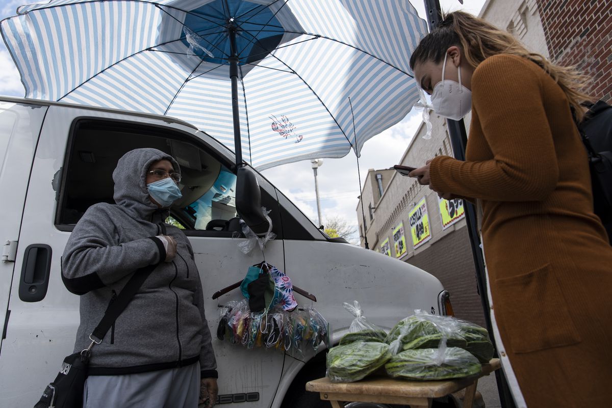 Luz Maria Cortez, right, with Increase the Peace,  helps sign up street vendors in Chicago’s Back of the Yards neighborhood for a small grant program to help street vendors during the coronavirus pandemic.