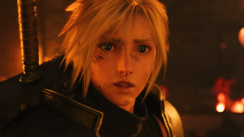 A very young-looking Cloud looks shocked, bathed in red firelight, in Final Fantasy 7 Rebirth