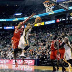 Utah Jazz point guard Trey Burke (3) goes to the basket with Houston Rockets power forward Dwight Howard (12) on his back during a game at EnergySolutions Arena on Monday, Dec. 2, 2013.