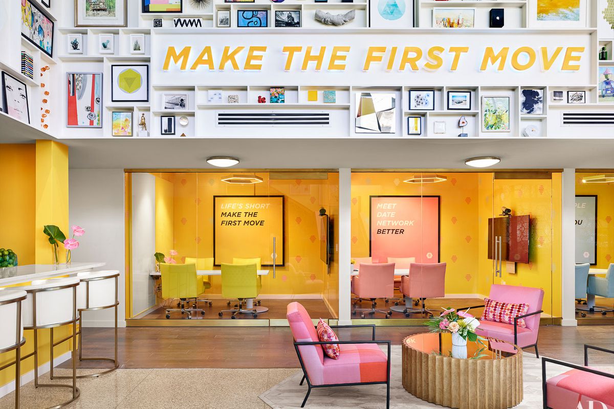 An open area with bright yellow walls and furniture, sign that says “Make the first move”