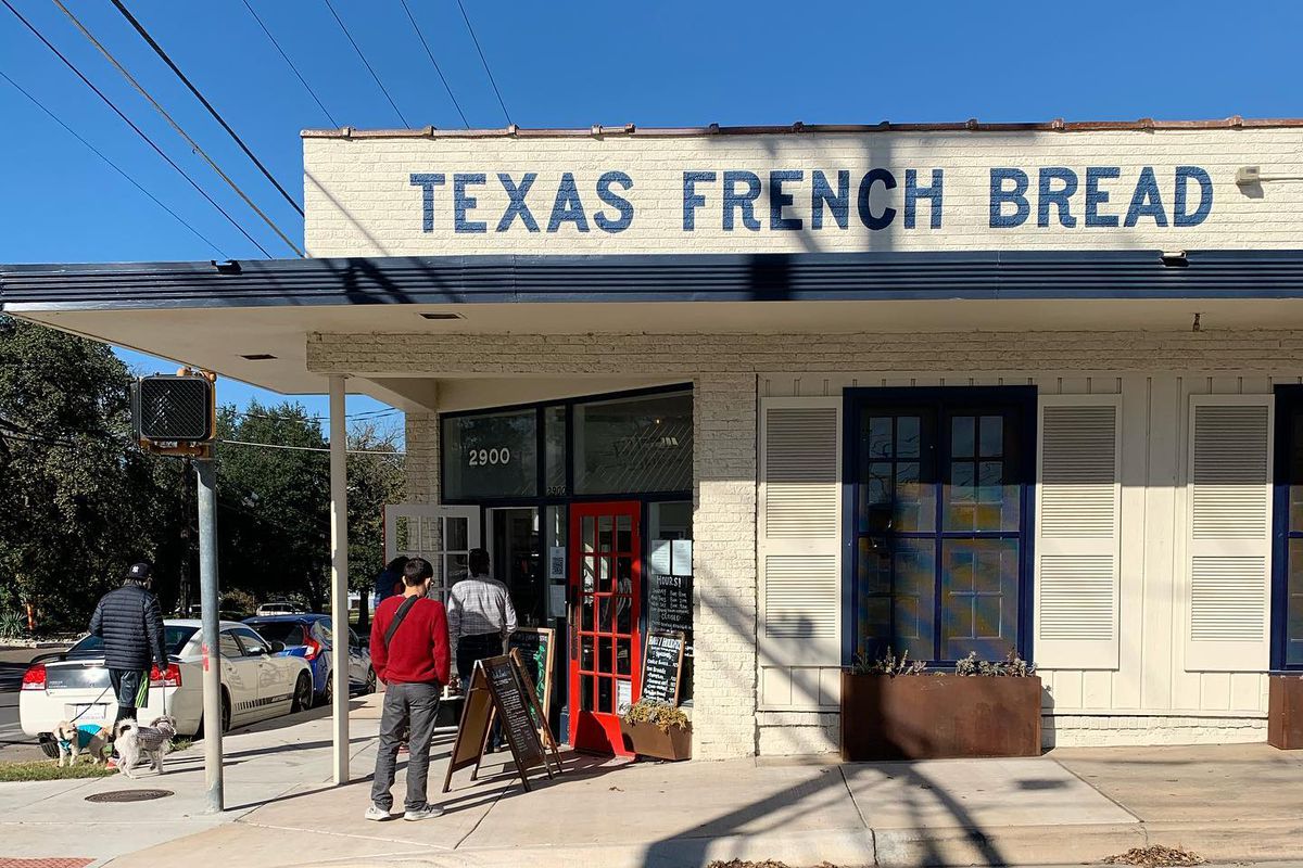 A restaurant building with the name “Texas French Bread” on top, and people are  waiting to enter.