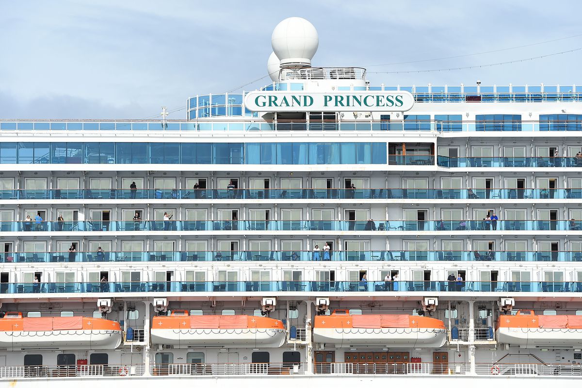 Passengers look out from aboard the Grand Princess cruise ship, operated by Princess Cruises