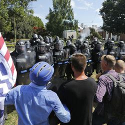 White nationalist demonstrators hold their ground against Virginia State Police as police fire tear gas rounds in Lee Park in Charlottesville, Va., Saturday, Aug. 12, 2017.  Gov. Terry McAuliffe declared a state of emergency and police dressed in riot gear ordered people to disperse after chaotic violent clashes between white nationalists and counter protestors. 