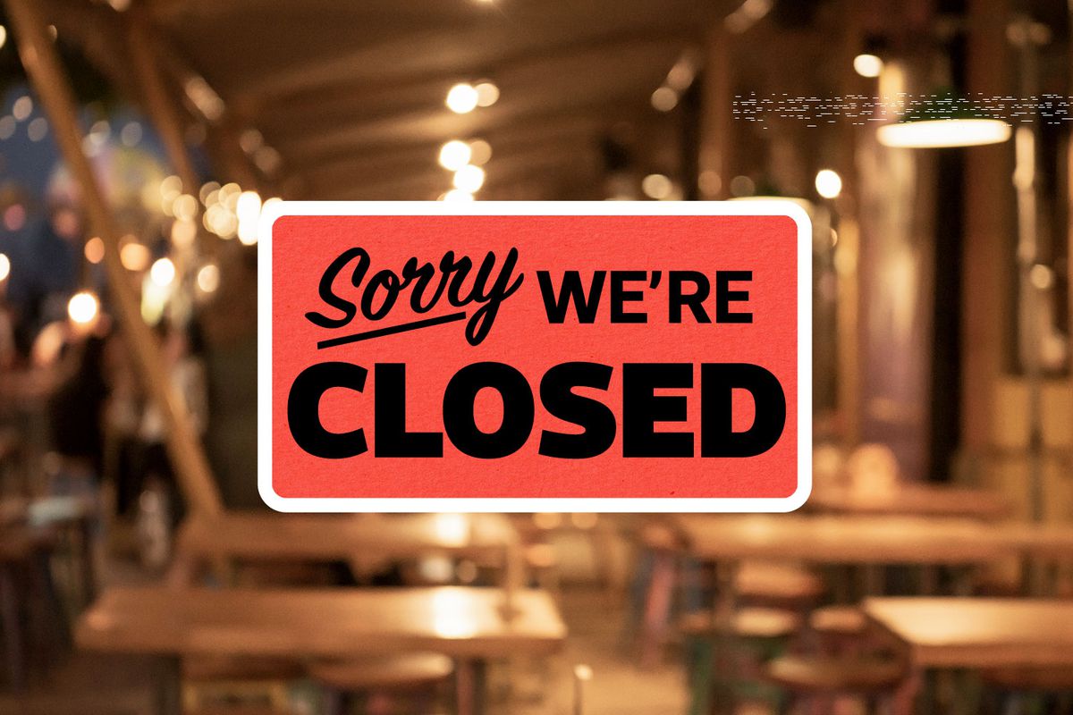 A graphic with the words “sorry we’re closed” with a blurred restaurant scene in the background.