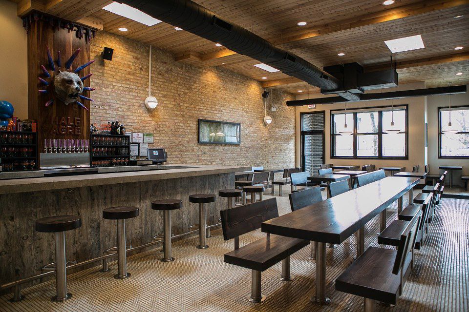 A barroom with a long communal table in the center of the room.
