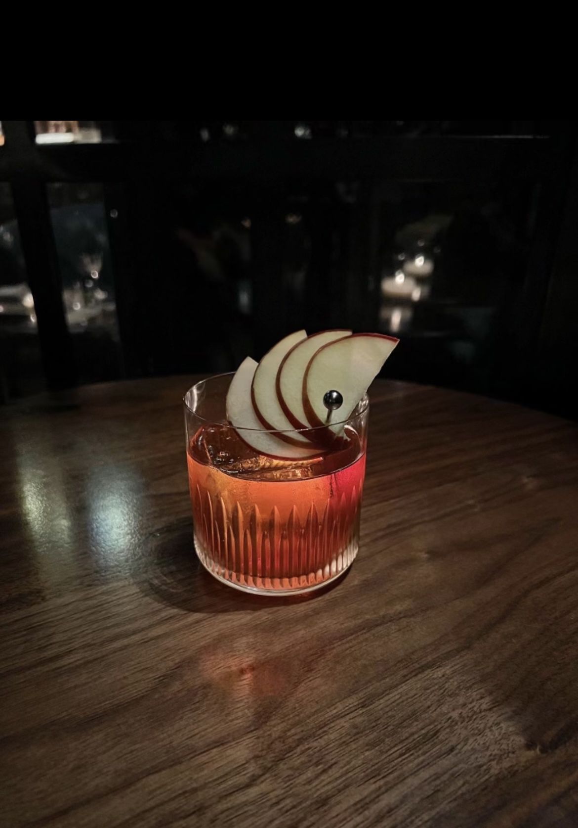 A cocktail garnished with apples.