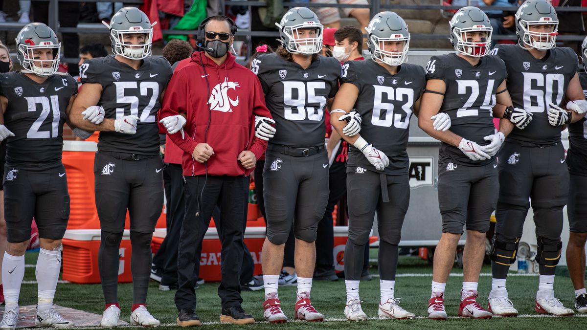 PULLMAN, WA - OCTOBER 16: Washington State head coach Nick Rolovich locks arms with teammates prior to a PAC 12 conference matchup between the Stanford Cardinal and the Washington State Cougars on October 16, 2021, at Martin Stadium in Pullman, WA.