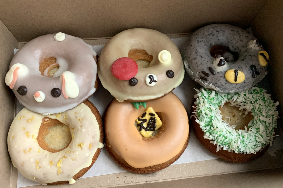 A box of dougnuts with frosting and animal designs.