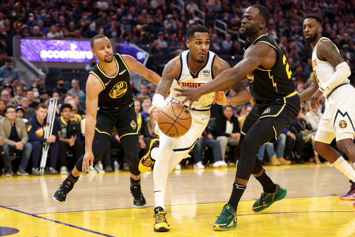 Monte Morris #11 of the Denver Nuggets is guarded by Stephen Curry #30 and Draymond Green #23 of the Golden State Warriors in the first half during Game One of the Western Conference First Round NBA Playoffs at Chase Center on April 16, 2022 in San Francisco, California.
